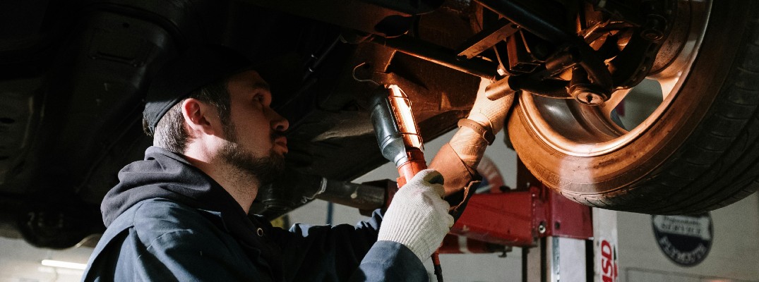 A photo of a person inspecting a car.