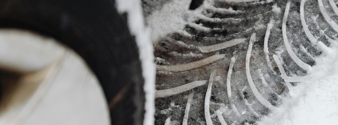 A stock photo of a tread mark in the snow from a winter tire.