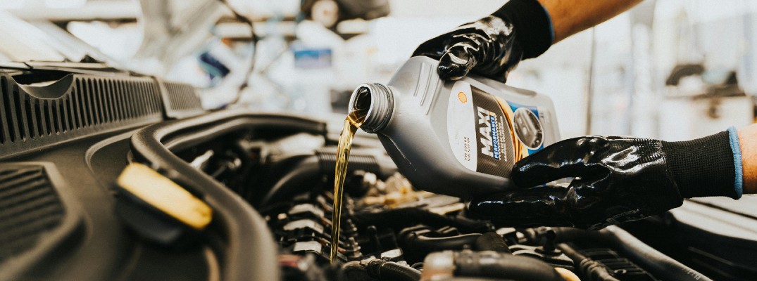 A stock photo of someone changing a car's oil.